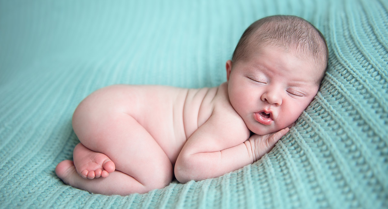 newborn-baby-on-knitted-rug.jpg